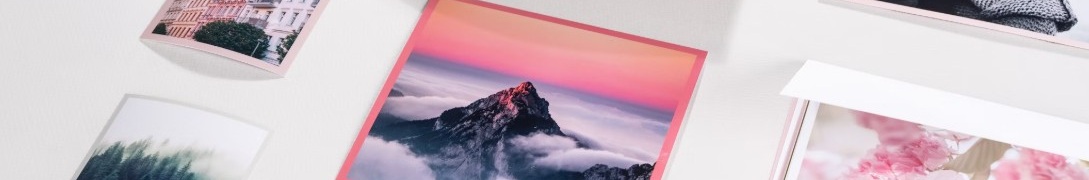 Utskrivna fotografier på ljus yta med motiv som berg, par, körsbärsblommor, skog och byggnader